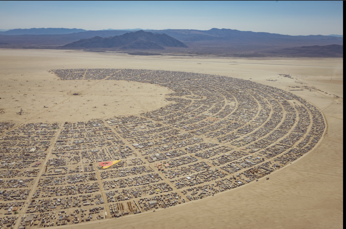 Aerial view of Black Rock City laid out in its arc-and-radial street plan on the open playa