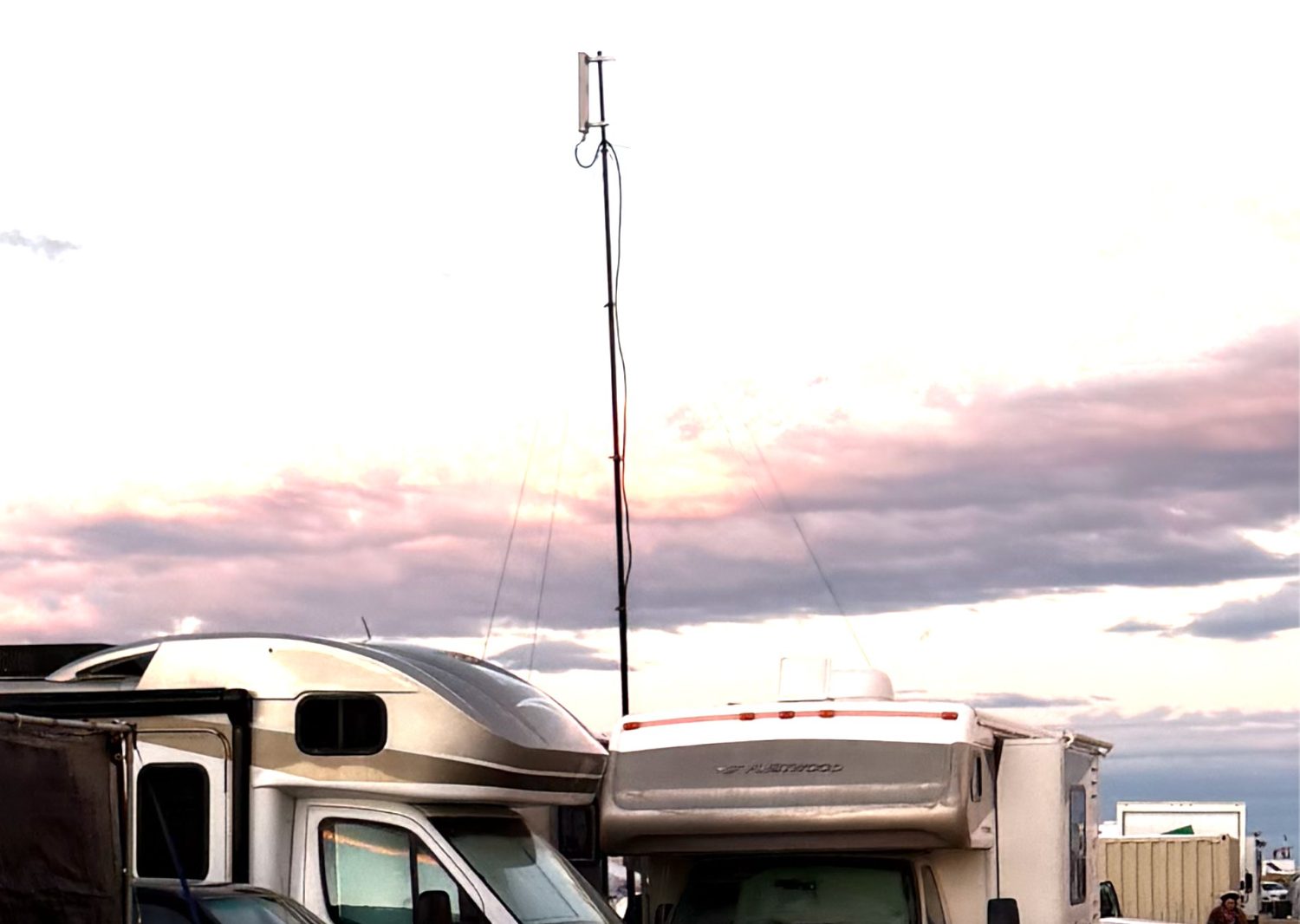 The sector antenna at the top of the mast at dusk, raised about 35 feet above the camp on the open playa