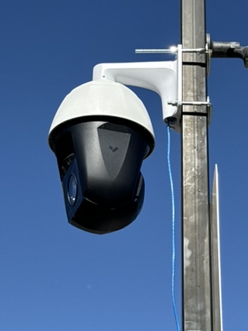 Verkada 4K PTZ dome security camera mounted on a pole against a blue sky